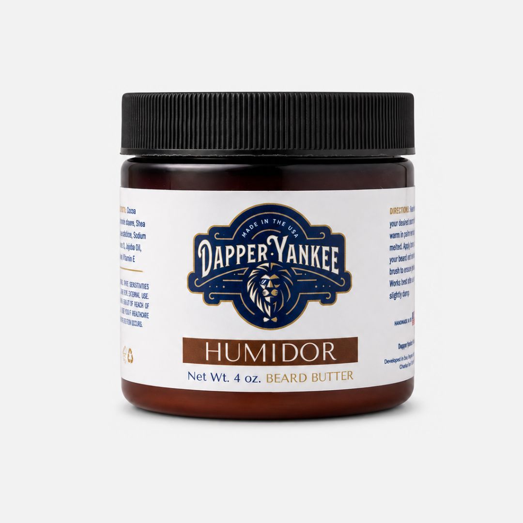 A 4 oz jar of Dapper Yankee Humidor Beard Butter with a black ribbed lid and a white label featuring the brand logo, set against a light gray background.