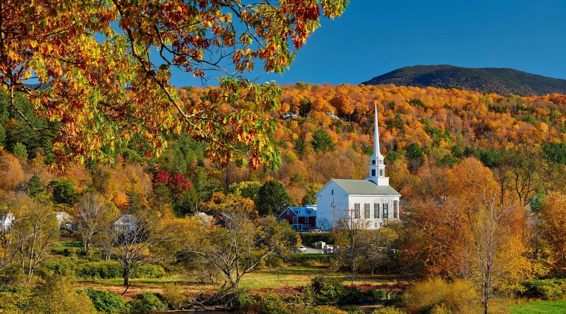 A landscape shot of Stowe, Vermont's iconic church in the fall.