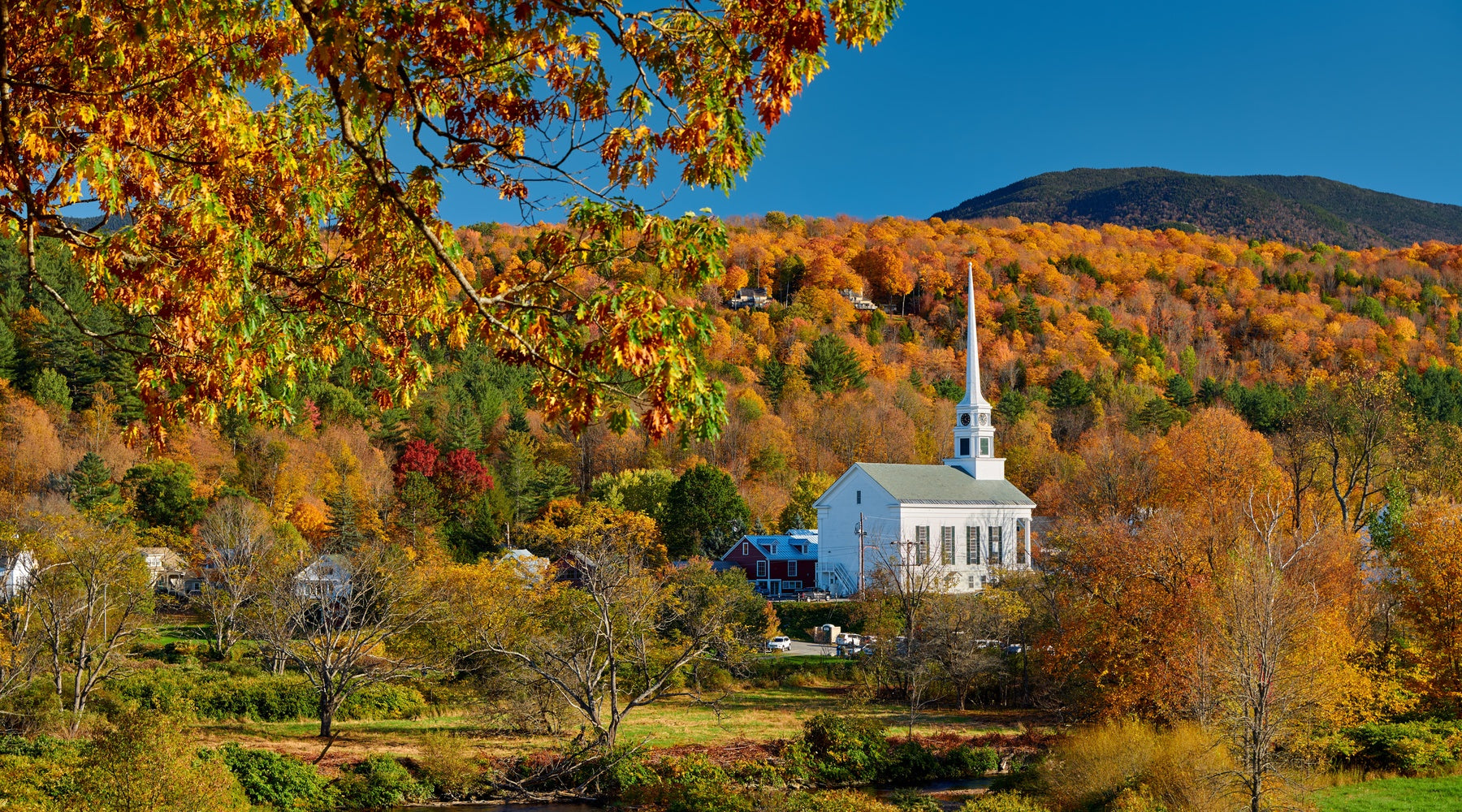 A landscape shot of Stowe, Vermont's iconic church in the fall.