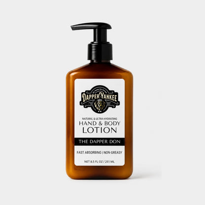 An amber plastic pump bottle of Dapper Yankee The Dapper Don Hand & Body Lotion on a light gray background.