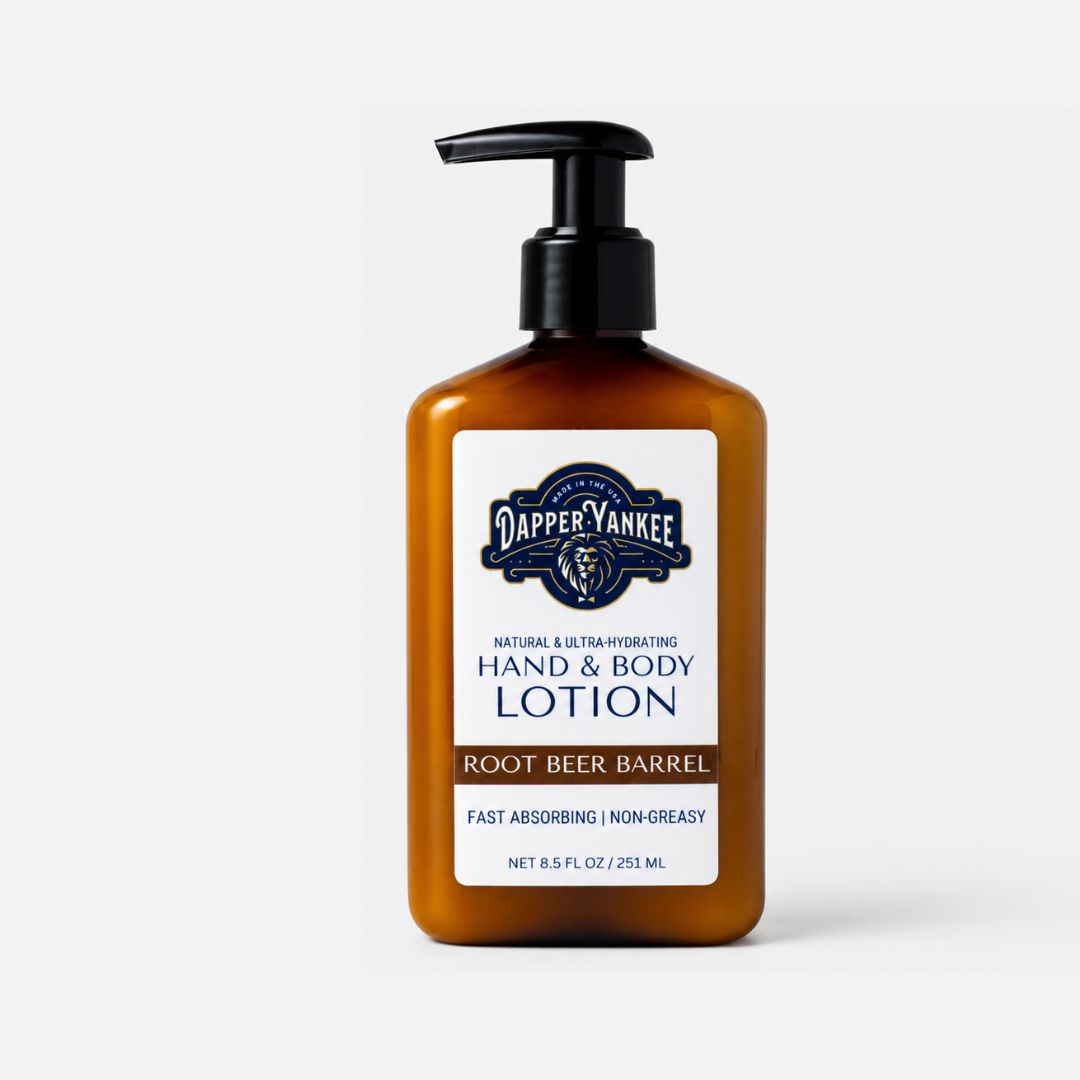 A bottle of Dapper Yankee Root Beer Barrel Hand & Body Lotion in an amber brown bottle with a black pump and a white label, set against a light gray background.