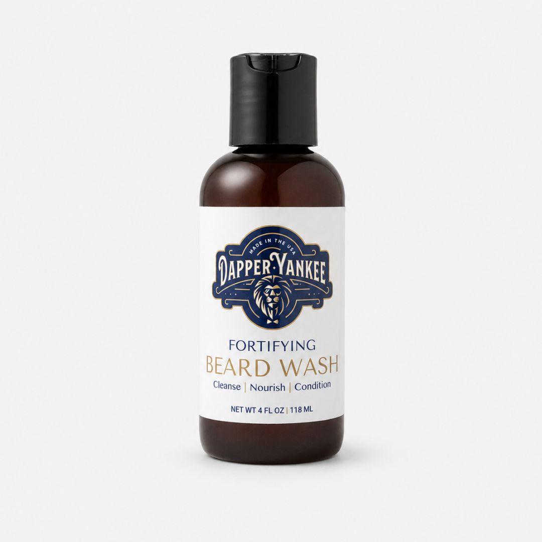 A 4 fl oz amber bottle of Dapper Yankee Fortifying Beard Wash with a black flip-top cap and a white label, set against a light gray background.