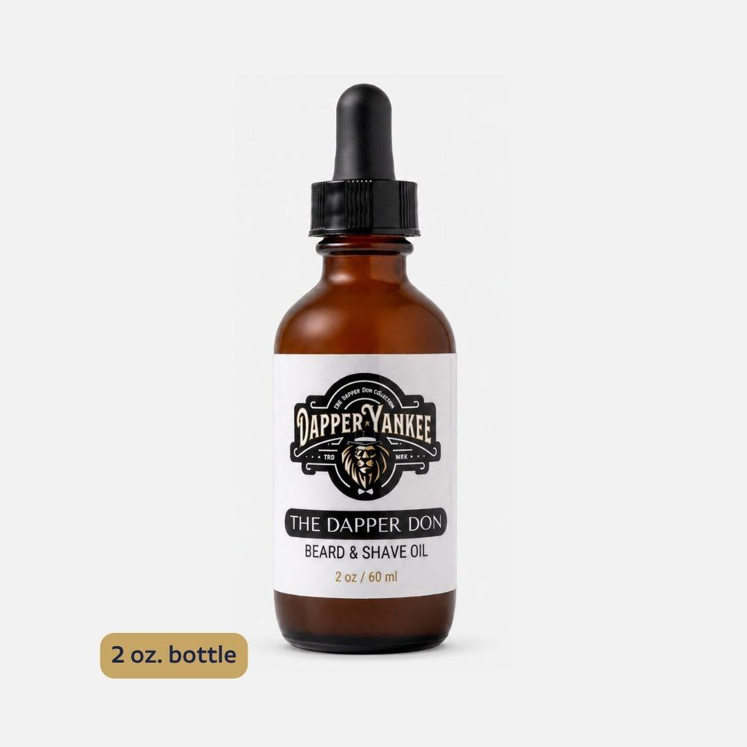 An amber glass dropper bottle of Dapper Yankee The Dapper Don Beard & Shave Oil on a light gray background, with a small '2 oz. bottle' label overlay in the bottom left corner.
