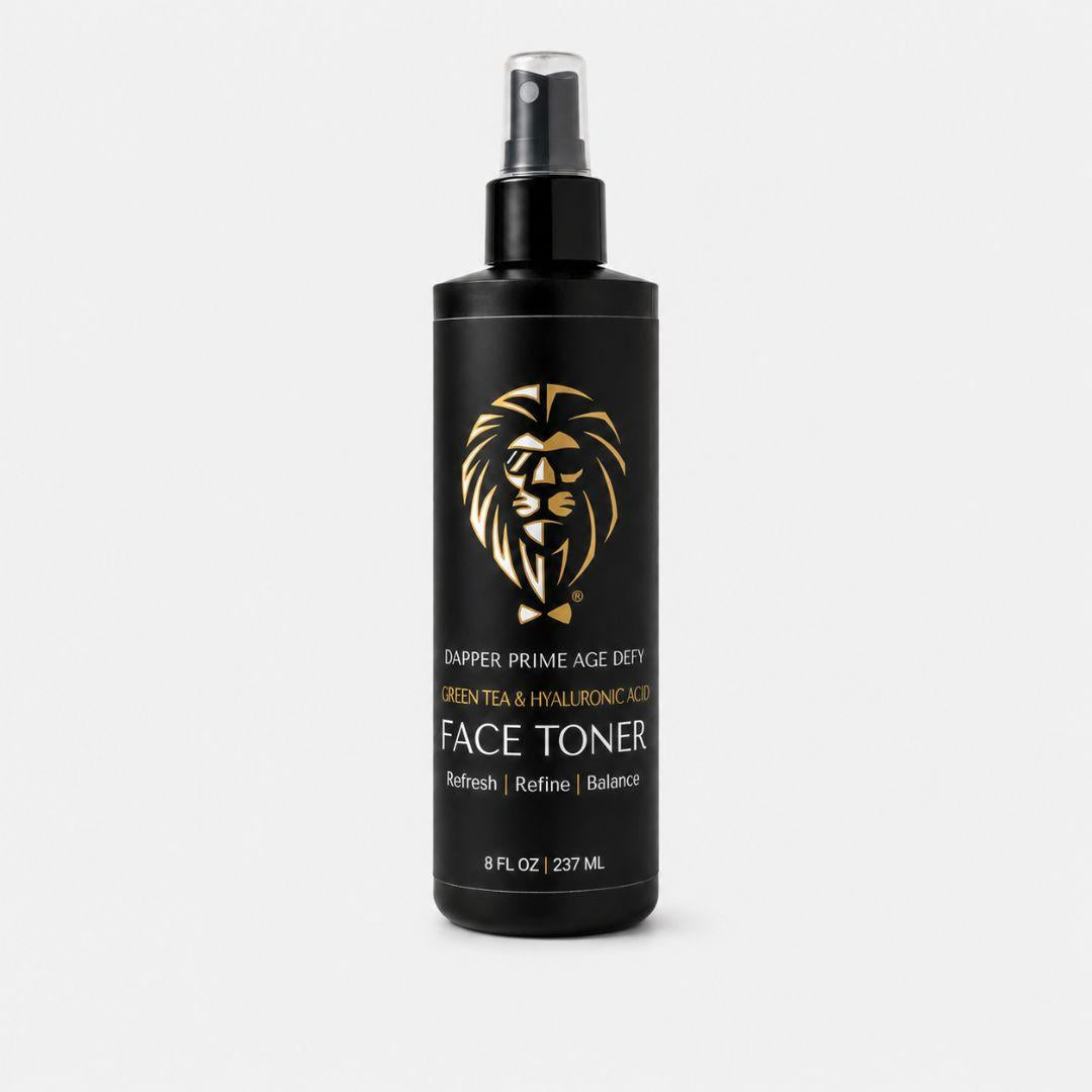 A black pump bottle of Dapper Prime Age Defy Face Toner with a gold lion logo and white text, set against a light gray background.