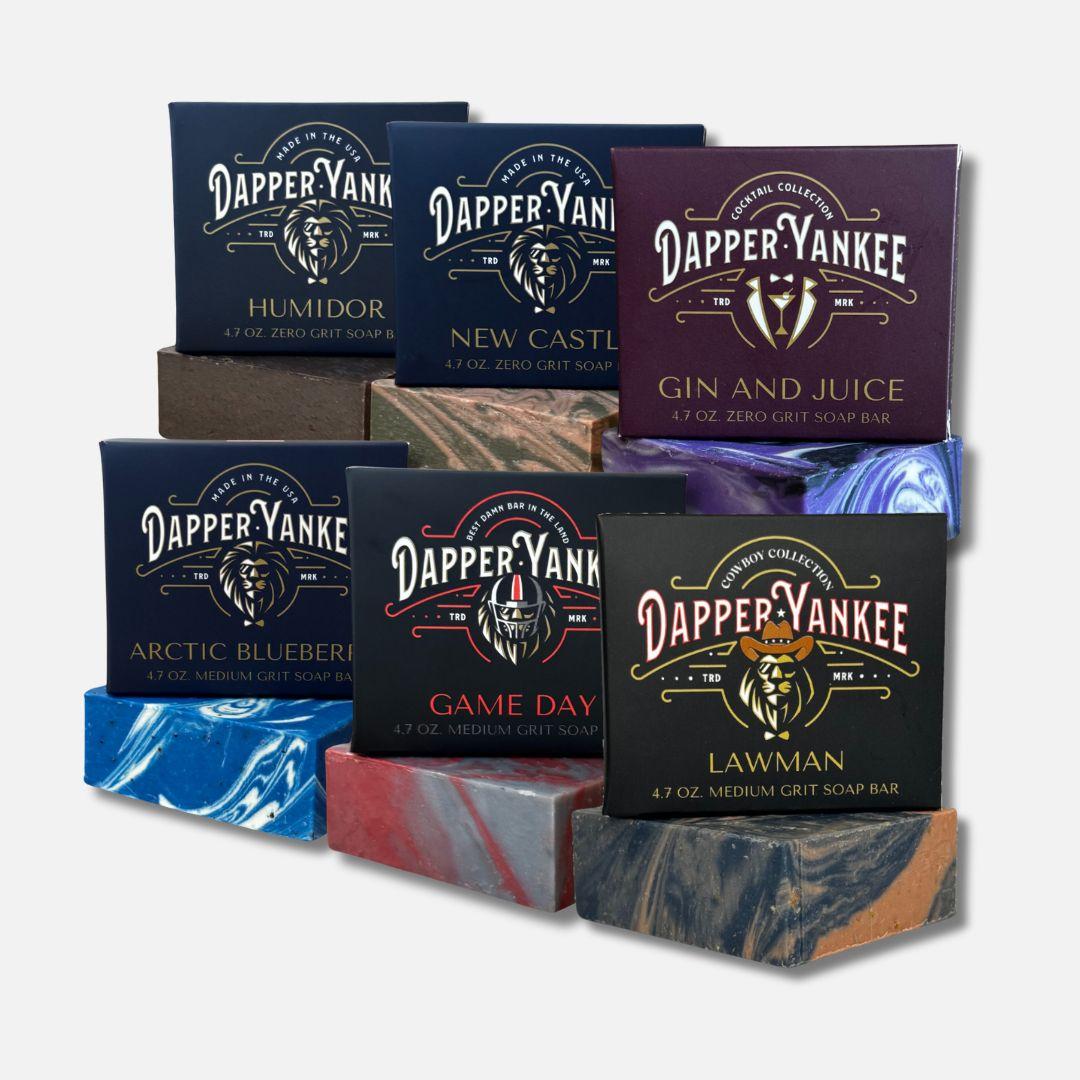 Collection of Dapper Yankee soap bars with various scents and designs on a white background