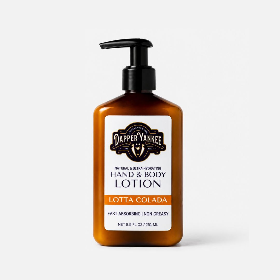 A bottle of Dapper Yankee Lotta Colada Hand & Body Lotion in an amber brown bottle with a black pump dispenser and a white label, set against a light gray background.