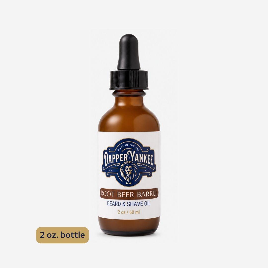 A 2 oz amber glass dropper bottle of Dapper Yankee Root Beer Barrel Beard & Shave Oil, shown on a light gray background with a small '2 oz. bottle' label overlay in the bottom left corner.
