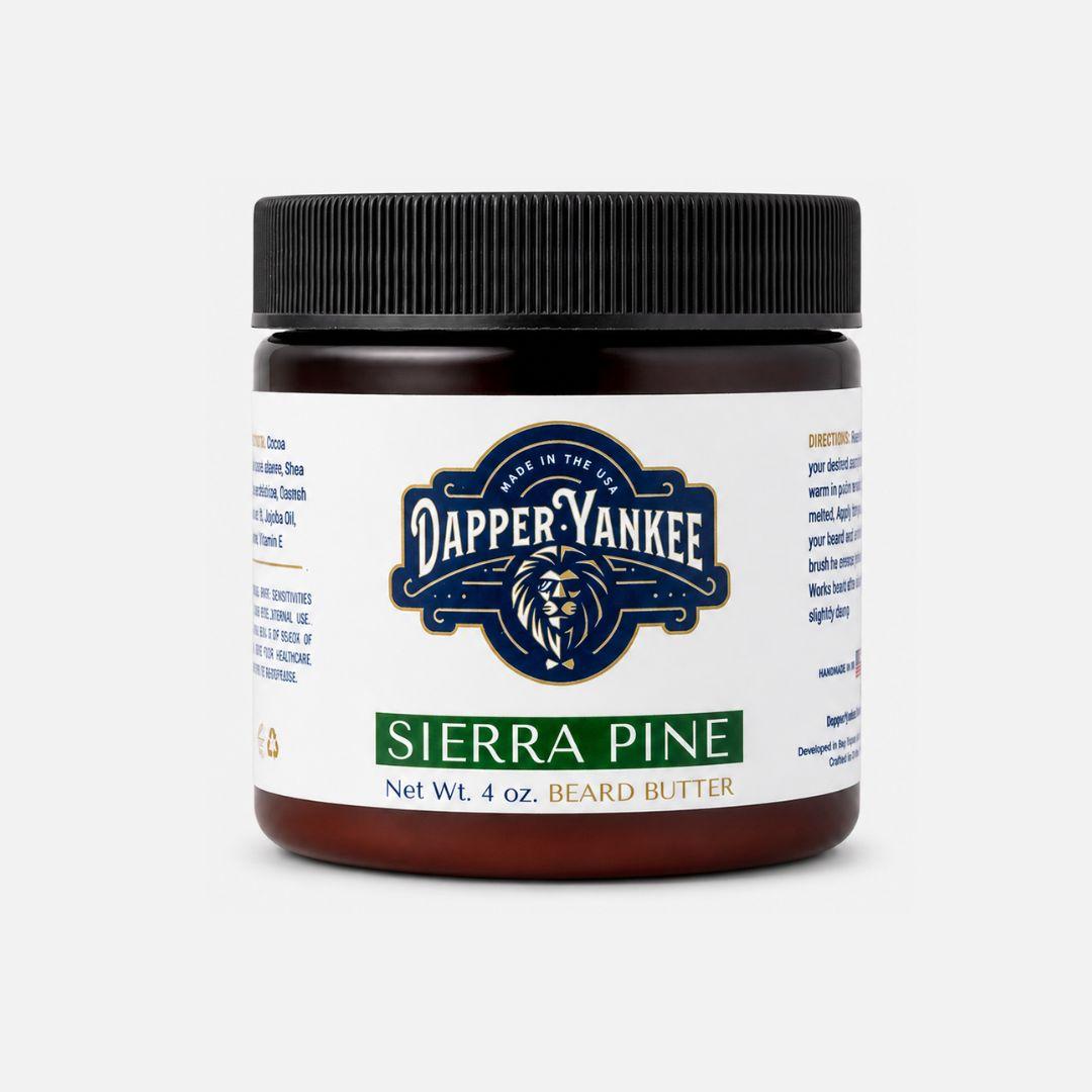A 4 oz jar of Dapper Yankee Sierra Pine Beard Butter on a light gray background. The product features a dark amber jar, a black ribbed screw cap, and a white label with a navy blue and gold Dapper Yankee logo and a green 'SIERRA PINE' text block.
