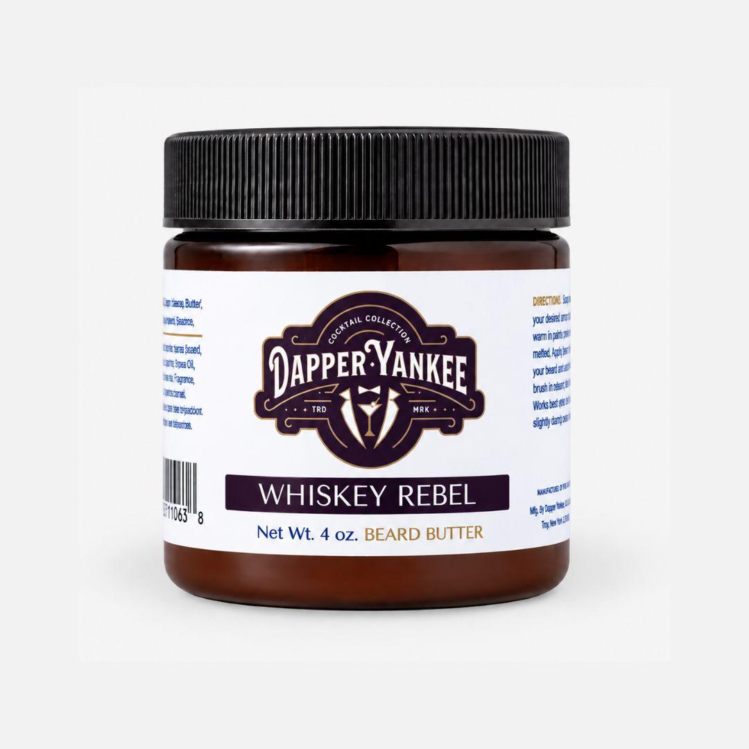 A 4 oz jar of Dapper Yankee Whiskey Rebel Beard Butter on a clean white background. The product features a dark amber jar, a black ribbed screw cap, and a white label with a Dapper Yankee logo and text.