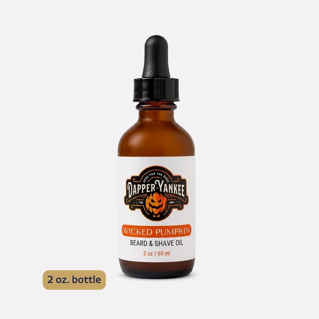 An amber glass dropper bottle of Dapper Yankee Wicked Pumpkin Beard & Shave Oil on a light gray background, with a small '2 oz. bottle' label overlay in the bottom left corner.