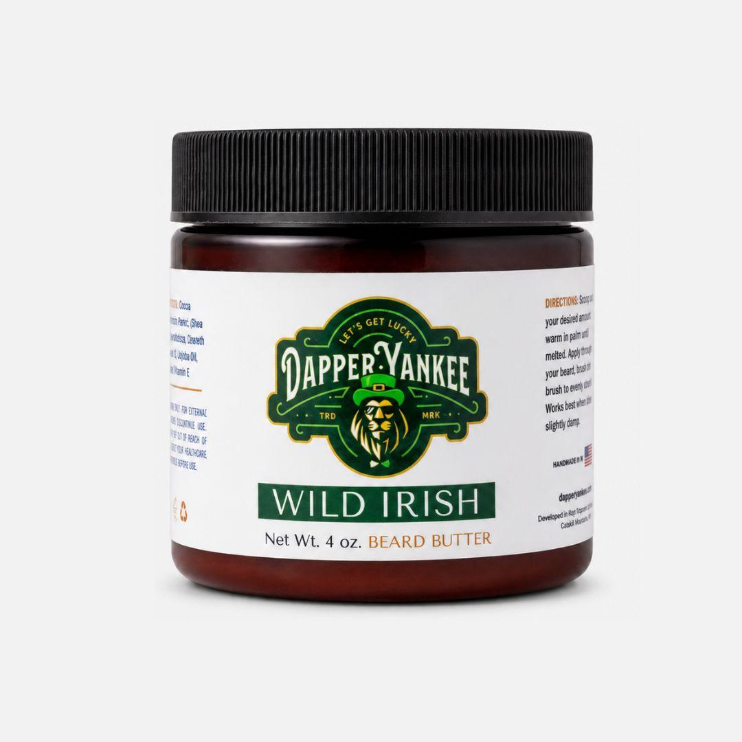 A 4 oz jar of Dapper Yankee Wild Irish Beard Butter on a light gray background. The product features a dark amber jar, a black ribbed screw-on lid, and a white label with green and gold branding.